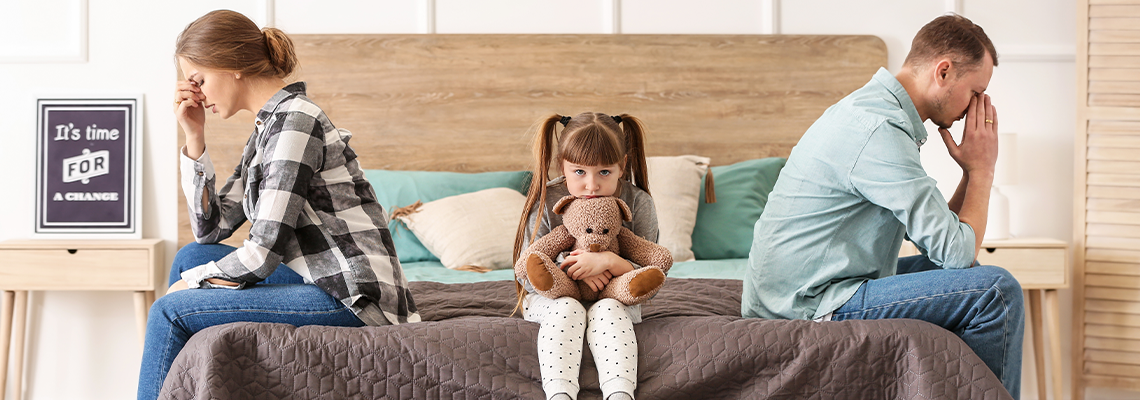 Sad family sitting on bed after quarrel
