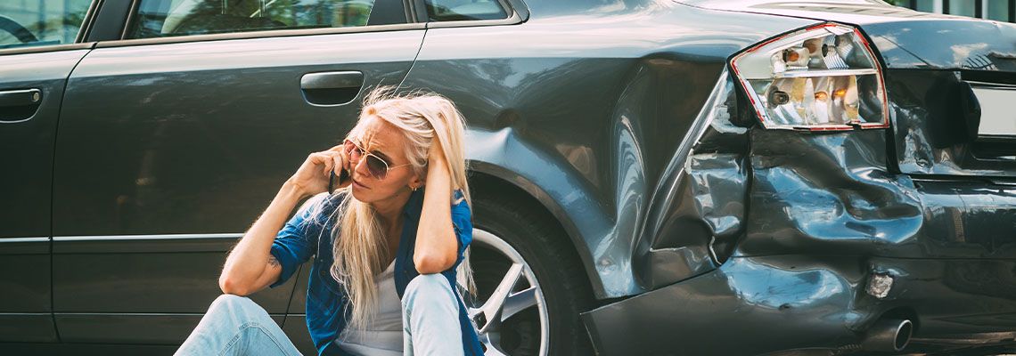 Frustrated girl calling help on phone after car accident