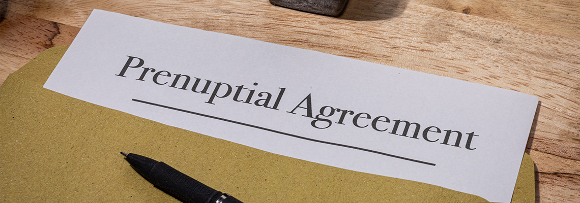 Prenuptial Agreement Document Resting on Wooden Desk with a Pen