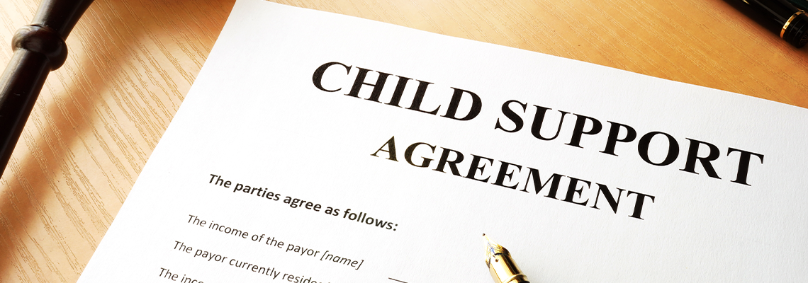 Document with the name child support agreement and pen on table