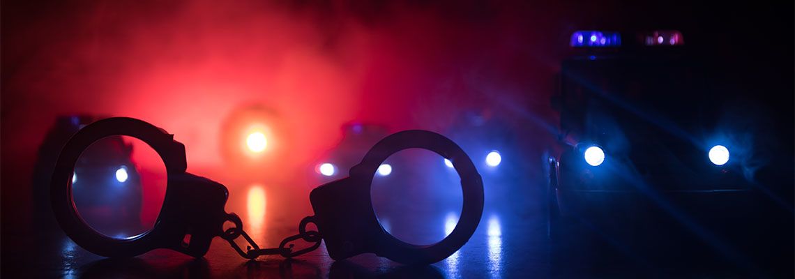 Handcuffs on the street at night with police car lights