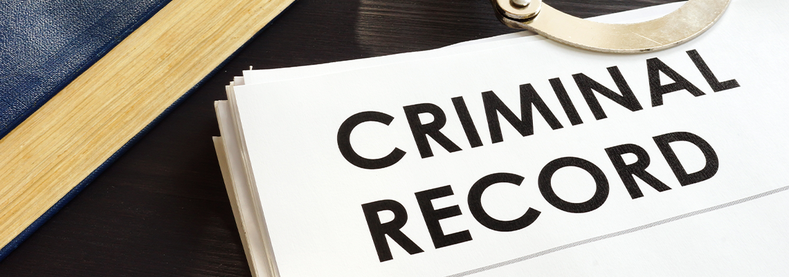 Criminal records and handcuffs on a desk