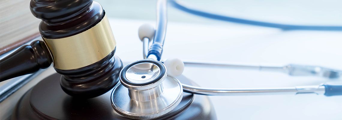 Gavel with stethoscope in table