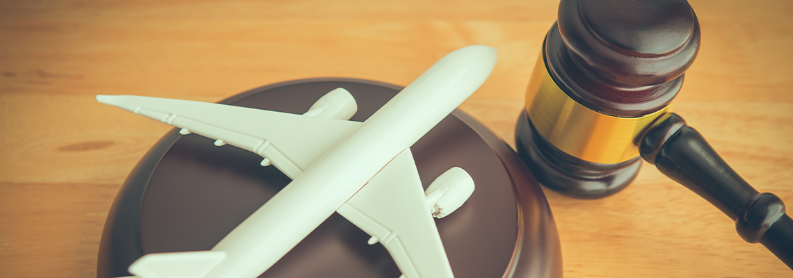 Judge hammer gavel and airplane on wooden table background
