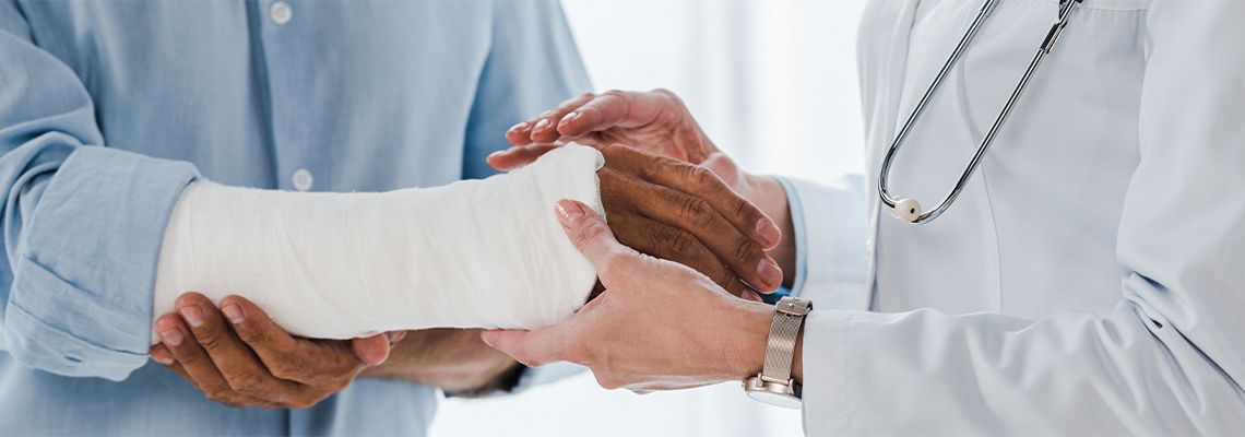Doctor treating broken arm of a man