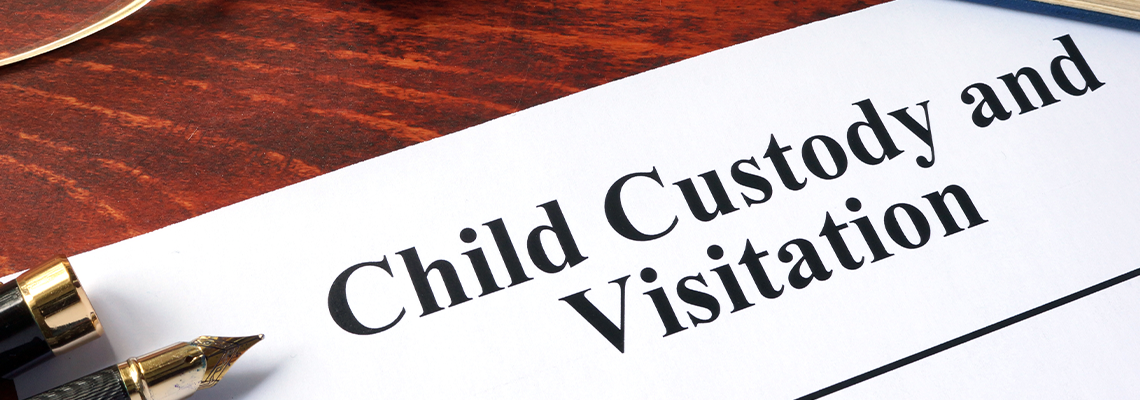 Child Custody and Visitation written on a paper and a book
