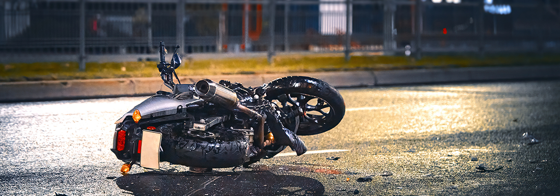 Motorcycle lying on asphalt after an road accident. Moto bike collision at night
