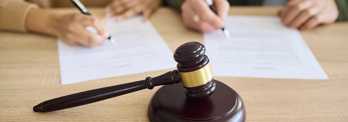 Couple signing divorce document at court with gavel