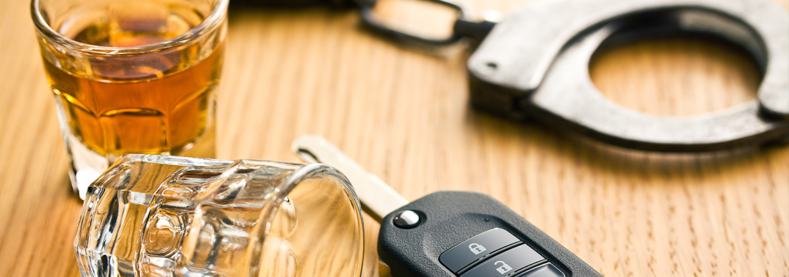 Alcohol, car key and handcuff on the table