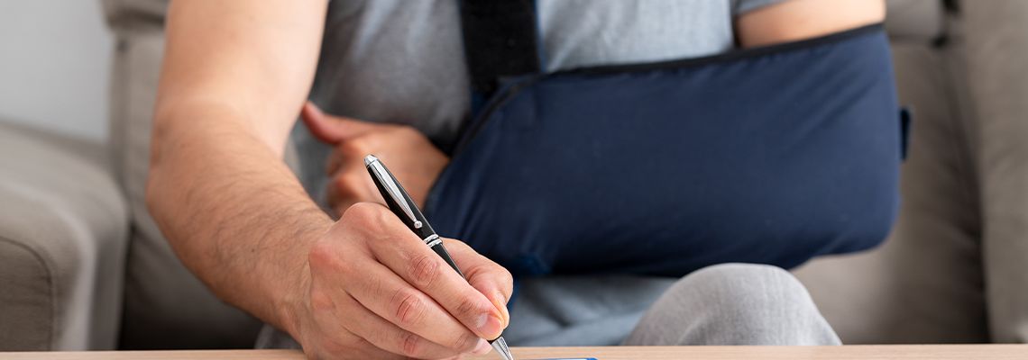 Man with broken arm filling compensation form