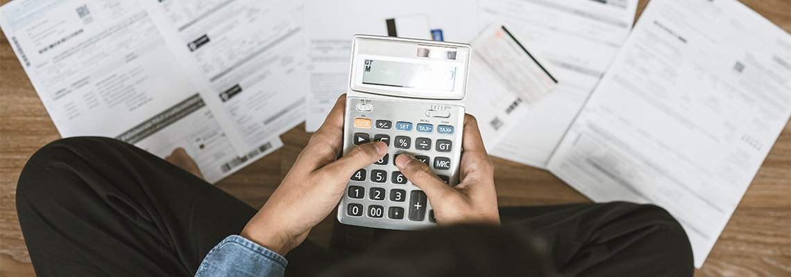 Man Sitting on The Floor Calculating Credit Report from Invoice or Bill