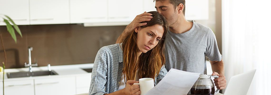 Husband consoling frustrated wife due to family debt