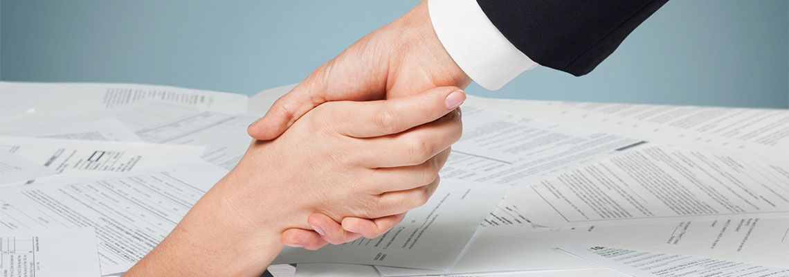 Hand pulling other hand from scattered documents