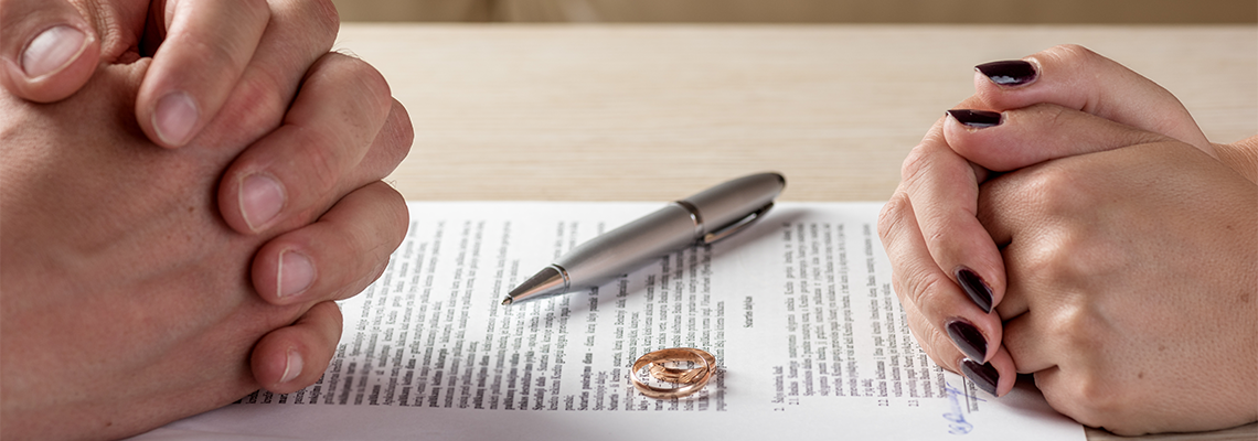 Wife and husband signing divorce documents or premarital agreement