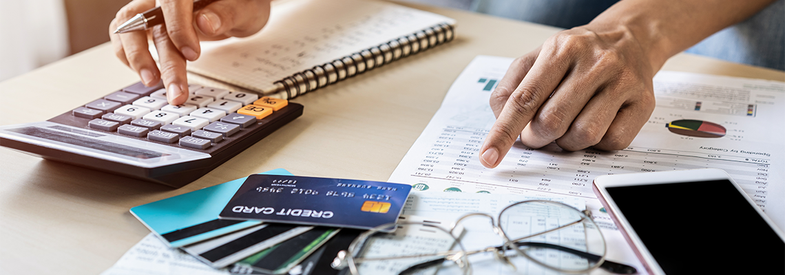 Woman checking bills, taxes, bank account balance and calculating credit card