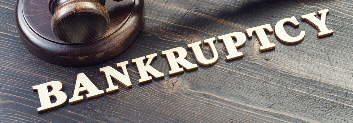 Judges gavel on desk and word bankruptcy spelled in wooden letters