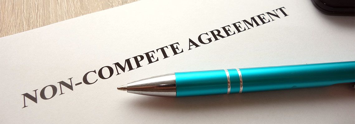 Non-compete agreement document with pen in table