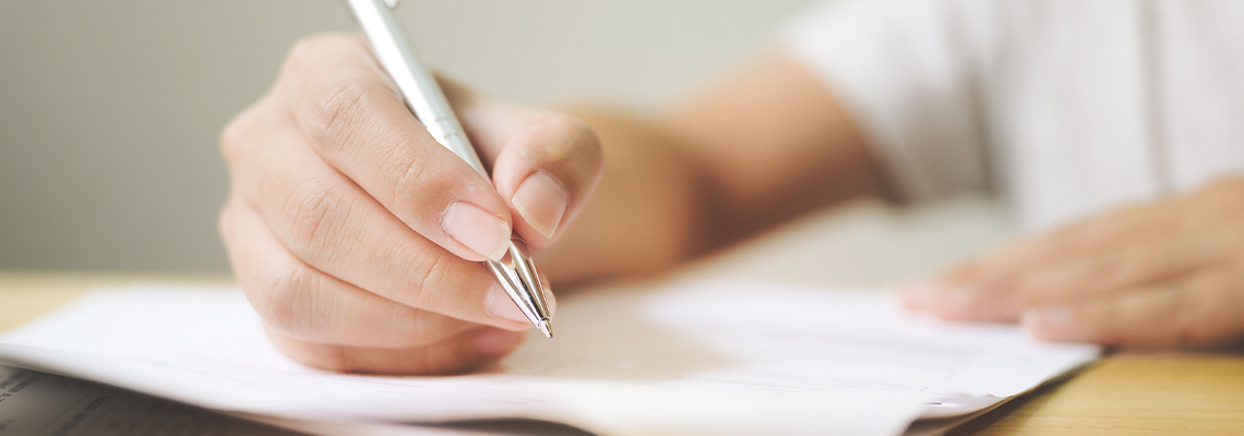 Hand of man signing signature filling in application form document