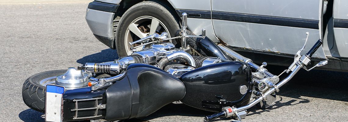 Motorcycle crash on street with a car