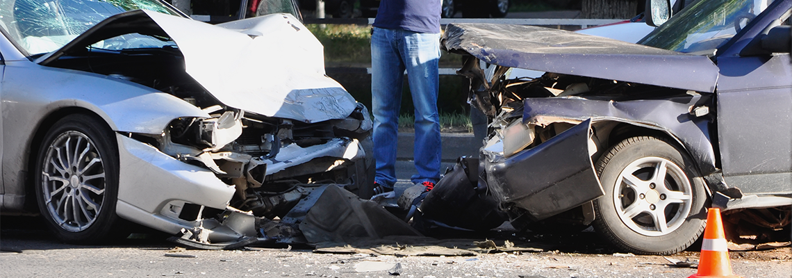 Man Standing Between Two Crashed Cars