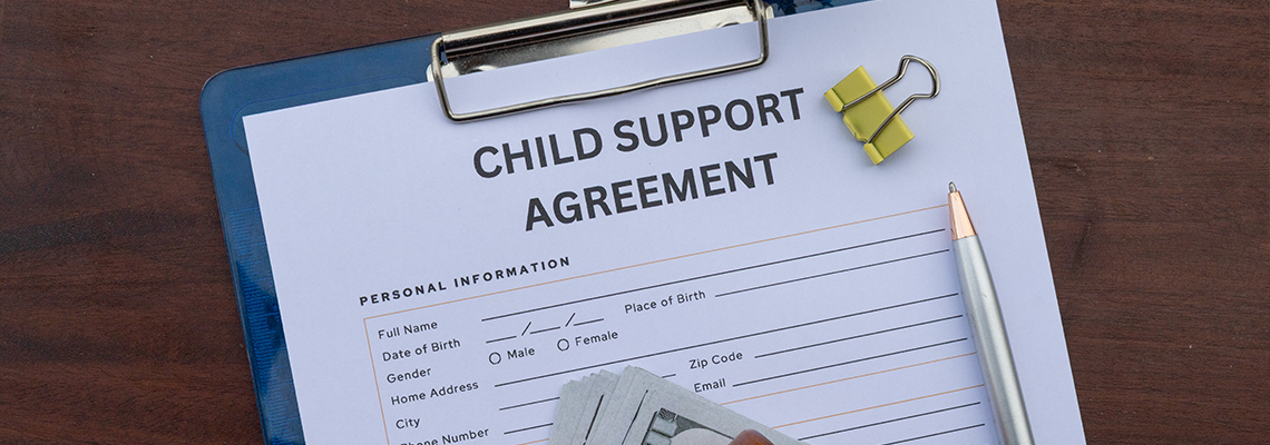 A formal child support contract placed in a clipboard on an office desk