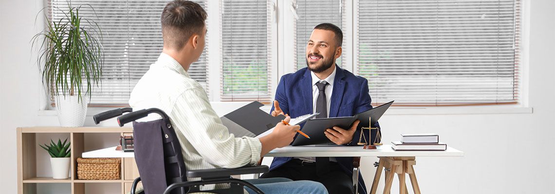 Injured man in wheelchair consulting with attorney