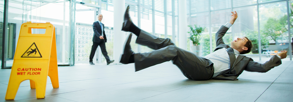 Businessman slipping on floor of office building