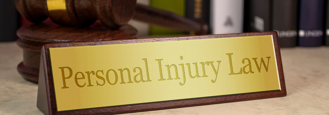 Golden sign on a table with law books and gavel with personal injury law