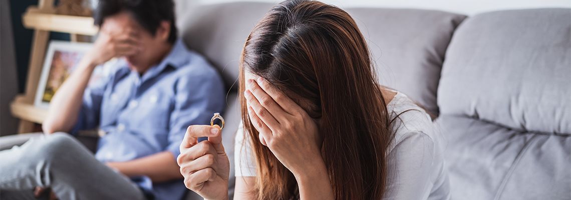 Sad wife taking off wedding ring after argument