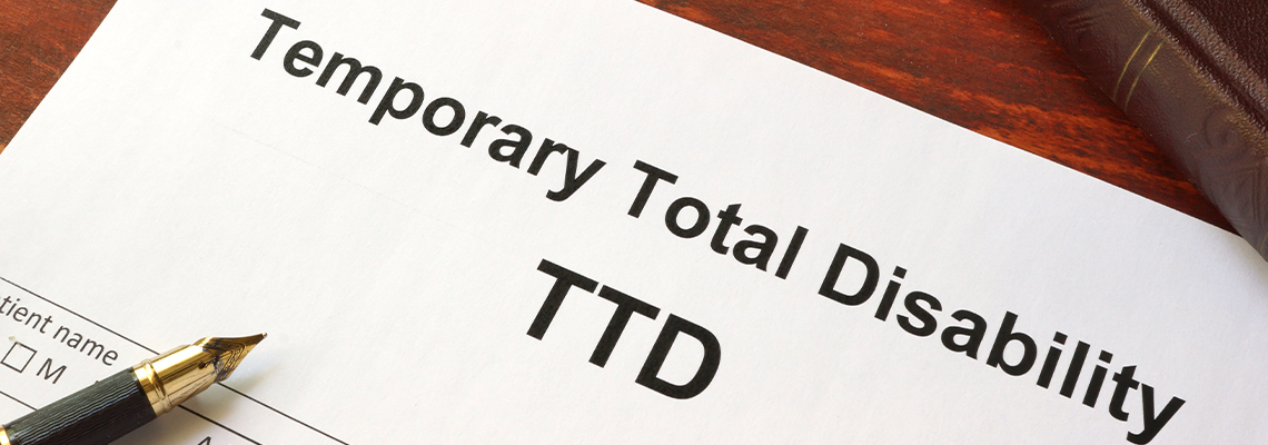 Temporary Total Disability (TTD) form on a wooden table