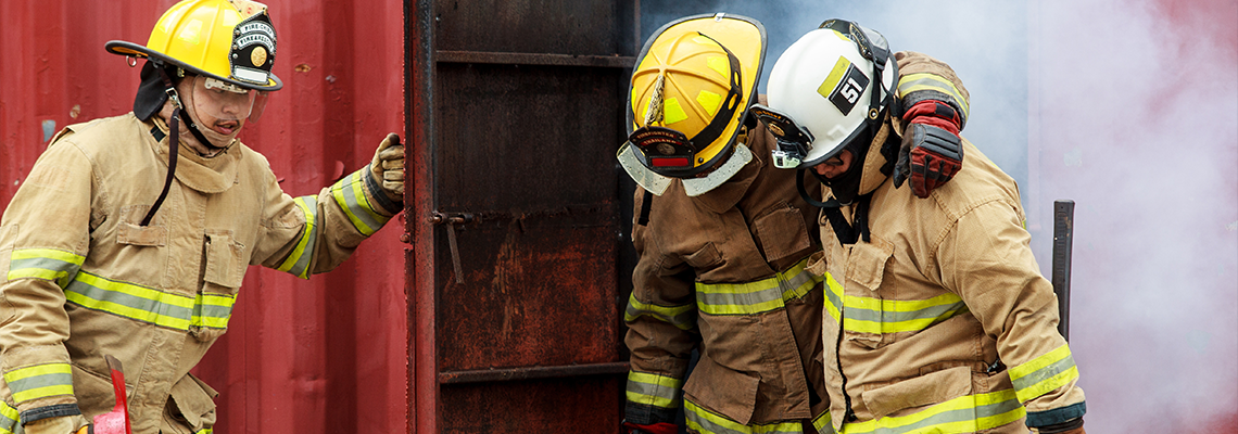Firefighters assisting injured colleague during emergency rescue