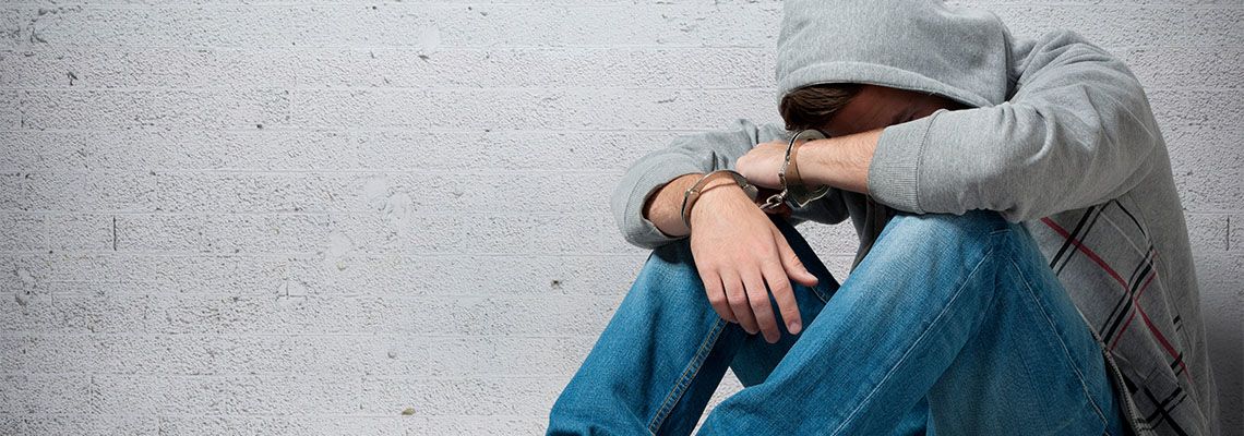 Arrested teenager with handcuffs on his hands
