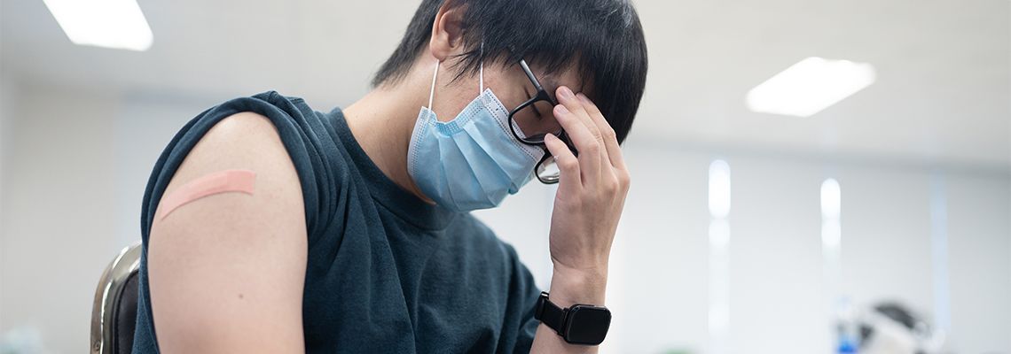 Man with headache and pain in hand after vaccination