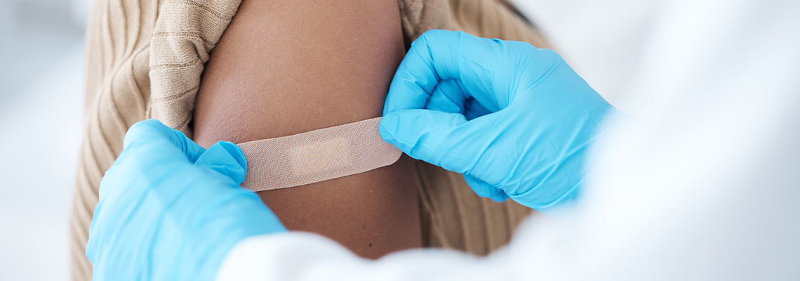 Doctor, vaccine and woman with plaster on arm for healthcare