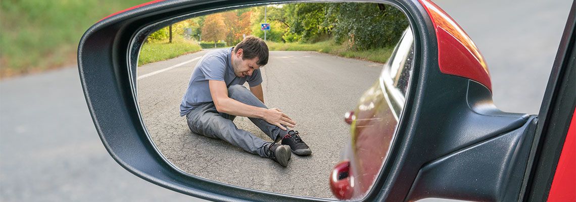 Injured man in rear view mirror of a car
