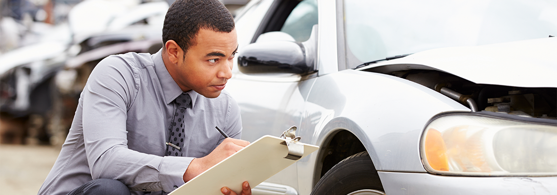 Loss Adjuster Inspecting Car Involved In Accident