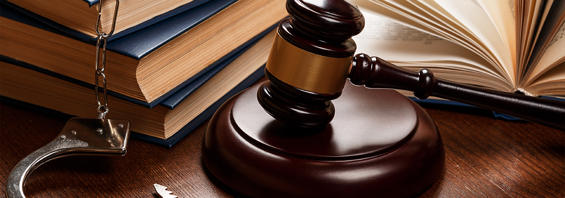 Gavel, books and handcuffs on a table