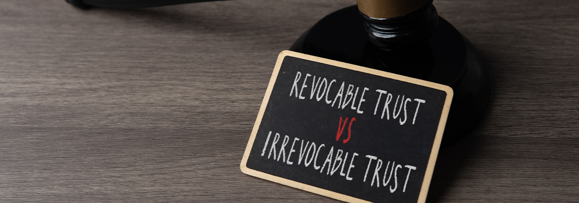 Judge gavel with a sign showing revocable trust versus irrevocable trust