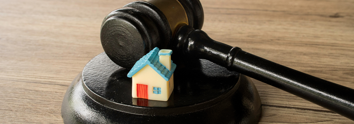 Miniature house model sitting on top of a judge sound block real estate