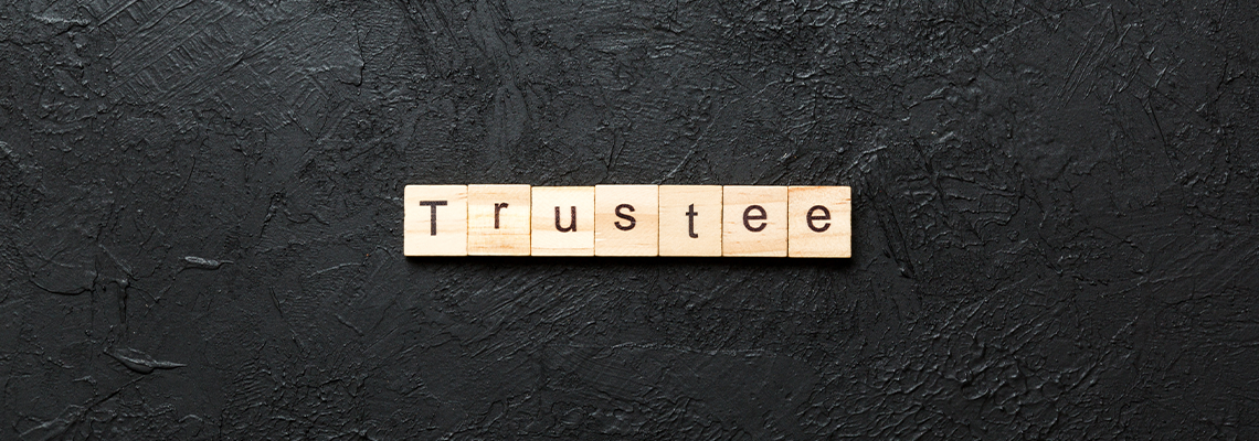 Trustee word written on wood block on table