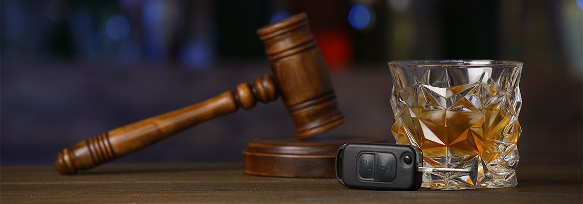 Car Keys, Glass of Alcohol and Gavel on table