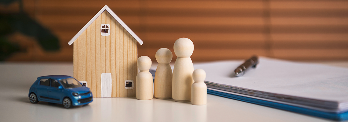 Family insurance planning with wooden house car and figurines