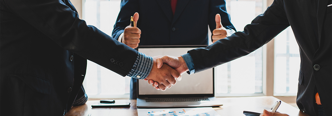 Business people shake hands while negotiating a business deal