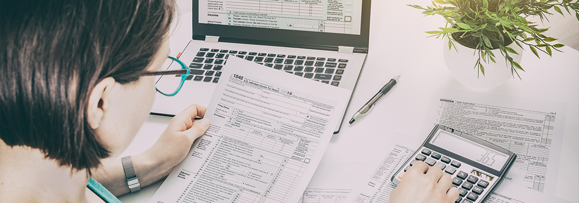 Women using calculator to fill tax form