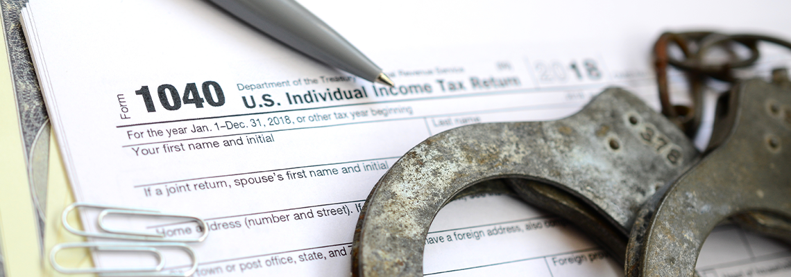 Police handcuffs lie on the tax form 1040