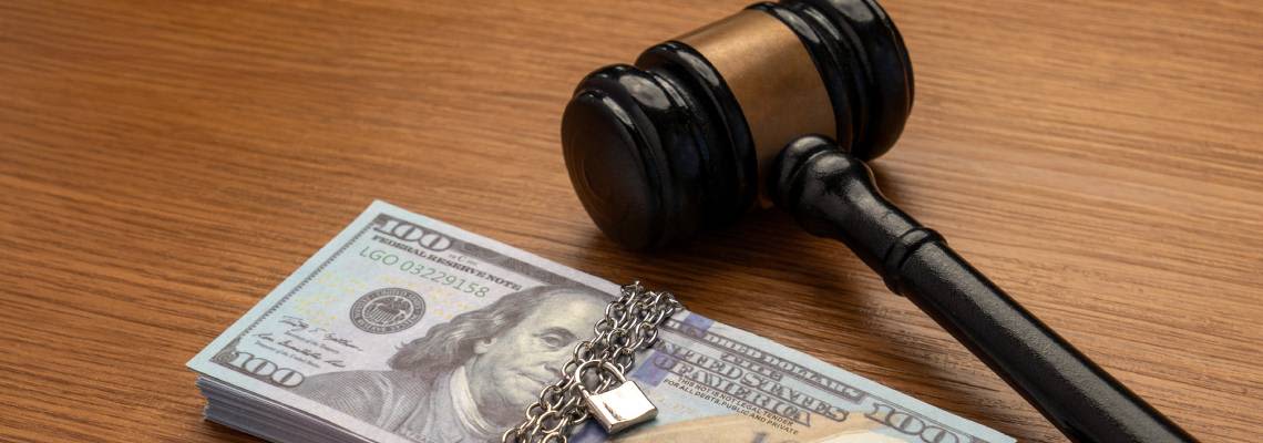 Gavel next to a stack of money bound by a metal chain