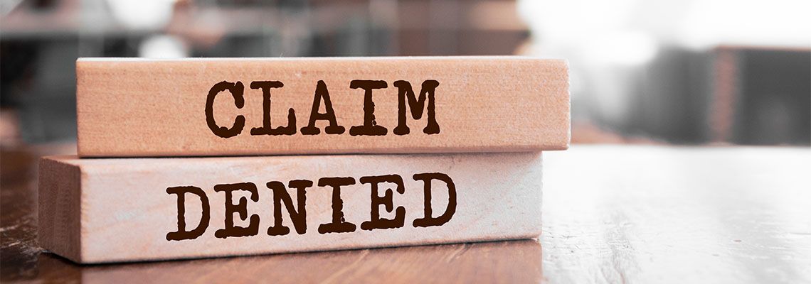 Wooden block with Claim Denied words