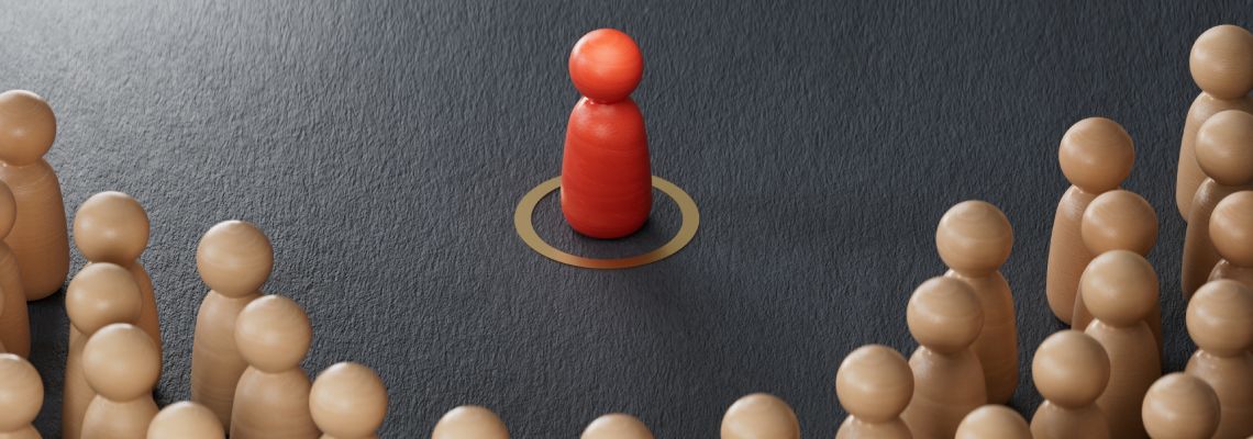 Many wooden pawns surrounding single red pawn