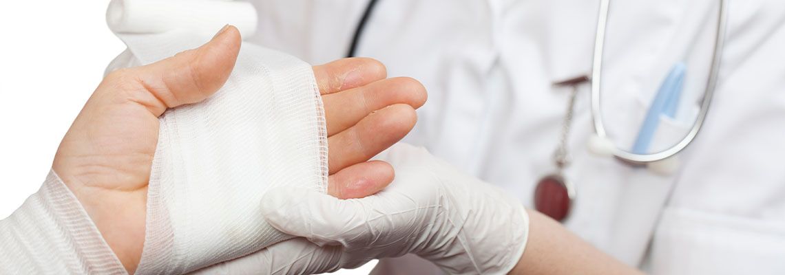 Doctor dressing burn injured hand
