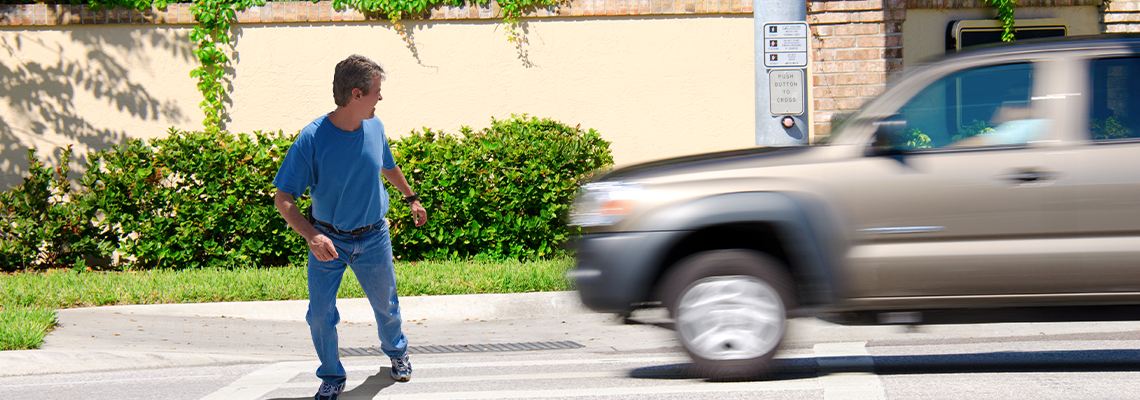 A man is jaywalking across an intersection when the signal is clearly showing